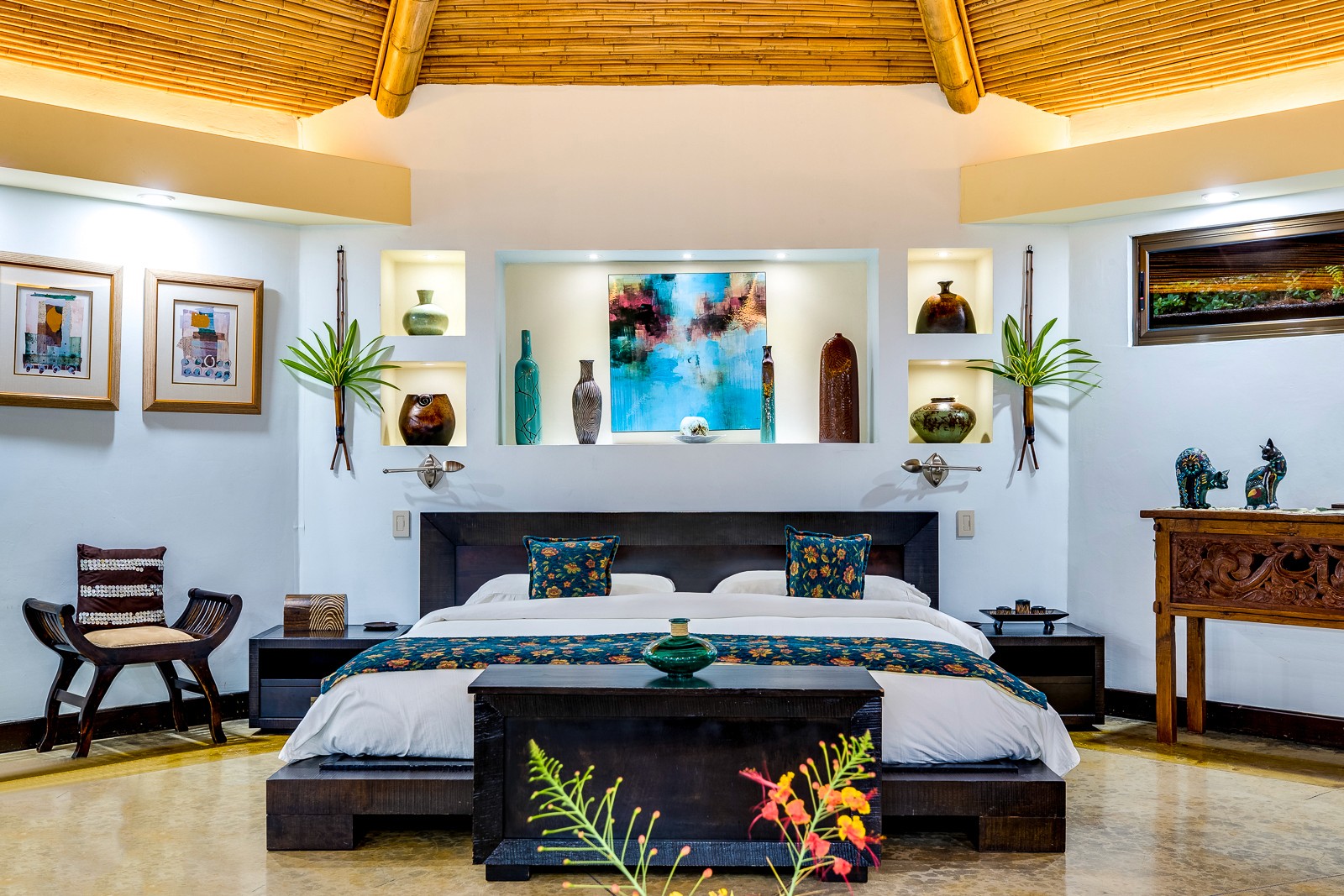 A private VIVARA villa bedroom with a carved wood bed and vaulted ceiling